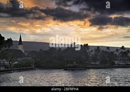 Tagesanbruch über Kailua Bay und die historische Mokuaikaua Kirche, die 1820 in Kailua-Kona auf der Big Island von Hawaii datiert. Stockfoto