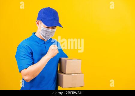 Asiatische junge Lieferarbeiter Mann in blauen T-Shirt und Mütze Uniform tragen Gesichtsmaske Schutz er niesen während Service-Kunden unter Coronavirus oder Stockfoto