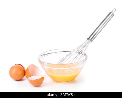 Metallbesen zum Schlagen von Eiern und Eiern in einer Schüssel auf weiß isoliert Stockfoto