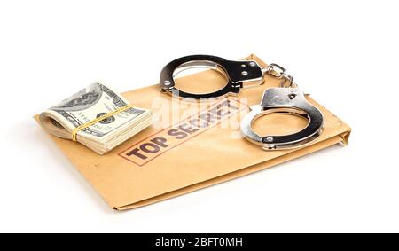 Dollar-Banknoten und Handschellen auf dem oberen geheimen Umschlag isoliert auf weiß Stockfoto