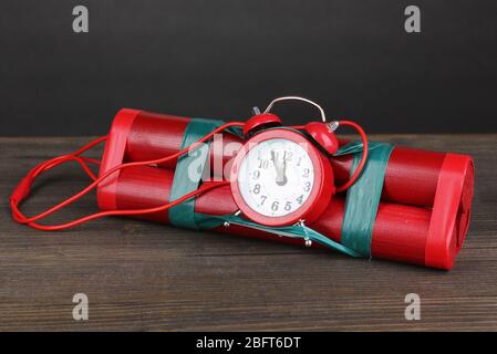 Zeitbombe aus Dynamit auf Holztisch auf grauem Hintergrund Stockfoto