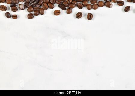 Französische Vanille Kaffeebohnen auf einem weißen Marmorhintergrund verstreut. Viel Kopienplatz. Stockfoto