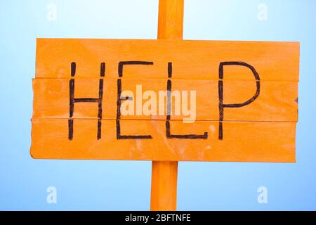 Hilfe Holzbrett auf blauem Hintergrund Stockfoto