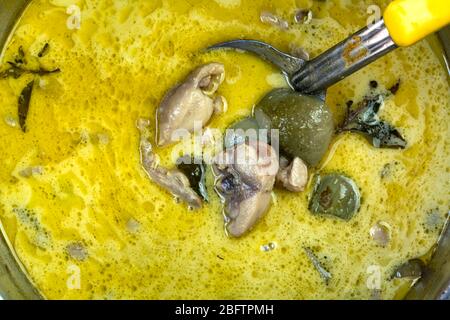 Original Thai Style Green Curry mit Huhn, Kokosmilch und etwas Kräutergemüse in einem Metalltopf. Stockfoto
