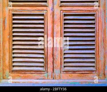 Fensterläden mit Lamellen aus Holz, in Süßigkeitenfarben pastellfarbene Farbe und mit warnischem Vintage-Finish. Stockfoto