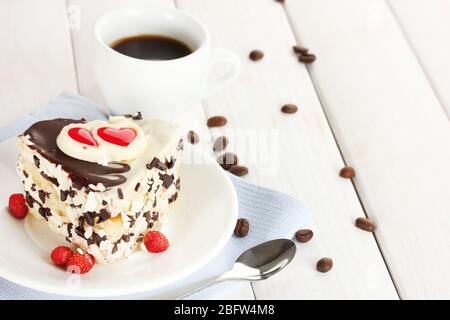 Süßer Kuchen mit Schokolade auf Teller und Tasse Kaffee auf Holztisch Stockfoto