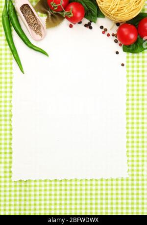 Papier für Rezepte, Gemüse und Gewürze auf grünem Hintergrund Stockfoto