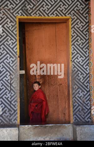 Ein junger Mönch in einer Tür bei Jakar Dzong, Bumthang District, Bhutan. Stockfoto