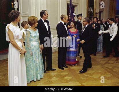 1976, Juli 27 - Osten - das Weiße Haus - Gerald R. Ford, Betty Ford, Malcolm Fraser, Tamara Fraser; Henry Kissinger, Shirley Temple Black - Gruß, Händeschütteln, stehend, spreche; formale Abnutzung - Erhalt der Linie für nach dem Abendessen an der Staatlichen Abendessen für die Premierminister von Australien Stockfoto