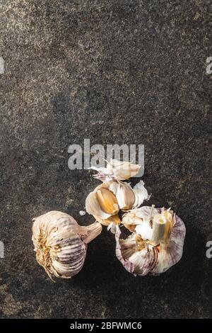 Weiße Knoblauchzwiebeln auf schwarzem Tisch. Draufsicht. Stockfoto