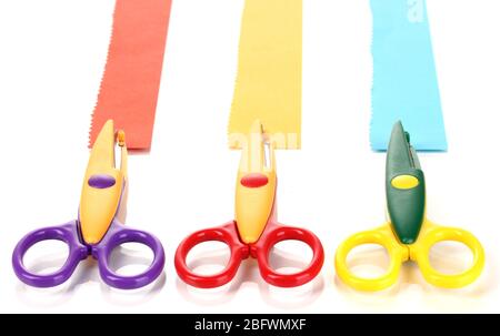 Bunte Zickzack-Schere mit Papierstreifen isoliert auf weiß Stockfoto