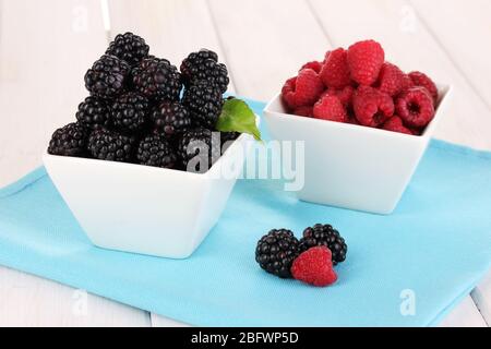 Reife Himbeeren und Brombeeren auf Holztisch Stockfoto