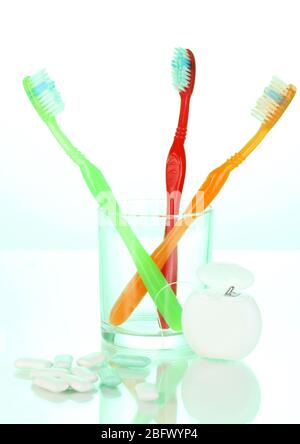 Zahnbürste aus Glas, Zahnseide und Kaugummi auf grünem Hintergrund Stockfoto