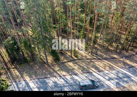 High-Winkel-Aufnahme eines Autos gehen sehr schnell auf Waldstraße. Drohne Fotografie Stockfoto