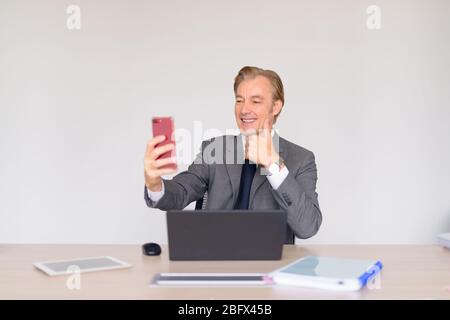 Glücklich reifen schönen Geschäftsmann im Anzug Selfie bei der Arbeit Stockfoto