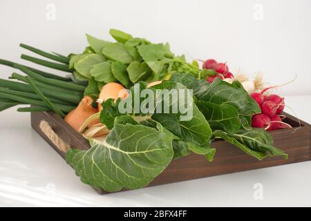 Hochwinkelansicht von Gemüse in Holzbehälter vor weißem Hintergrund Stockfoto