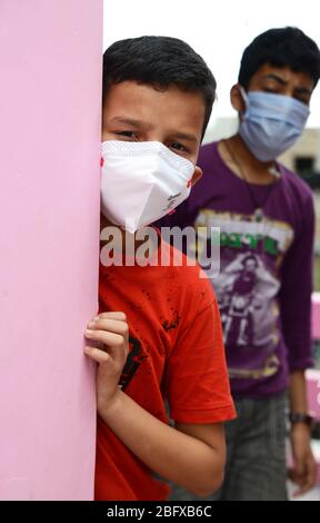 Besorgtes und besorgtes Kind mit schützender Gesichtsmaske, das die verlassenen Straßen in Indien beobachtet - wegen Covit19 Coronavirus-Pandemie. Sein Land (I Stockfoto