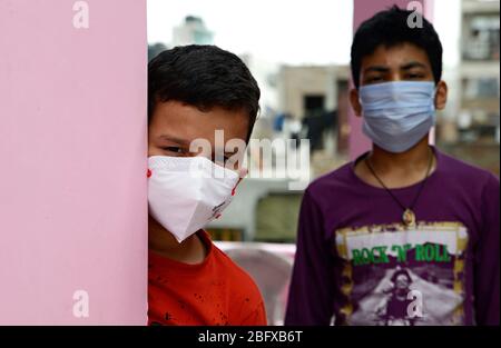 Besorgtes und besorgtes Kind mit schützender Gesichtsmaske, das die verlassenen Straßen in Indien beobachtet - wegen Covit19 Coronavirus-Pandemie. Sein Land (I Stockfoto