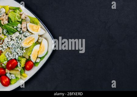 Hausgemachter Bio-Salat. Gemüsesalat mit Tomaten, Eiern, Speck, roquefort mit französischem Käse, Hühnerfleisch, Salat. Stockfoto