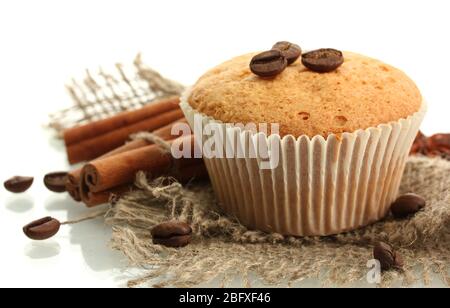 Leckere Muffin-Kuchen auf Burlap, Gewürze und Kaffeesamen, isoliert auf weiß Stockfoto