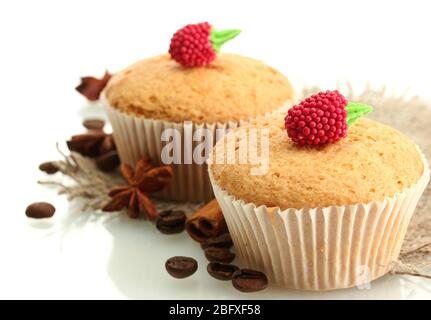 Leckere Muffin-Kuchen auf Burlap, Gewürze und Kaffeesamen, isoliert auf weiß Stockfoto