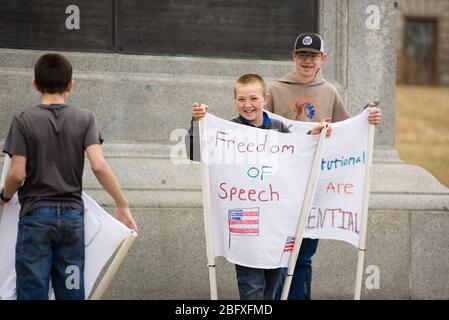 Helena, Montana - 19. April 2020: Kinder lächeln und lachen mit Redefreiheit Zeichen bei einem Protest im Capitol über den Aufenthalt zu Hause oder Stockfoto