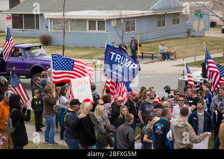 Helena, Montana - 19. April 2020: Demonstranten protestieren im Kapitol gegen die Schließung von Unternehmen durch die Regierungen wegen des Coronavirus. Halteflaggen A Stockfoto