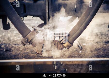 Aus einem Rohr einer alten Dampfeisenbahn kommt sehr heißer Dampf Stockfoto