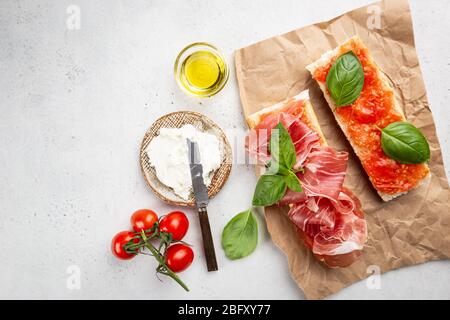 Spanisches Frühstück, Draufsicht. Toast oder Sandwich mit Jamon, Käse und Tomatensauce Stockfoto