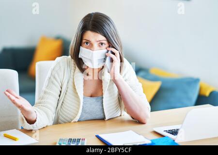 Erschöpfte Frau, die während der Coronavirus-Pandemie zu Hause arbeiten will Stockfoto