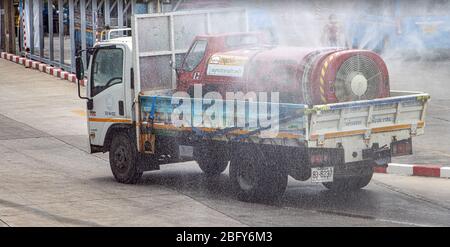 SAMUT PRAKAN, THAILAND, APR 17 2020, EIN LKW mit kleinerem Spezialauto mit Zisterne desinfiziert eine Straße. Spray aus Tank Auto reinigt Stadt. Stockfoto