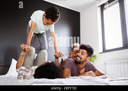 Glückliche Familie zusammen spielen auf einem Bett zu Hause Stockfoto