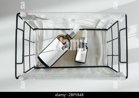 Flaschenauffüllung. Zwei Kosmetikflaschen in Metallkorb. Draufsicht, Kopierbereich. Schönheitskonzept Stockfoto