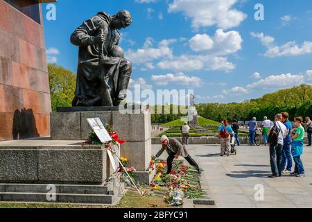 9. Mai 2016, Berlin, am Sowjetischen Kriegsdenkmal im Treptower Park, einem Denkmal und zugleich einem Militärfriedhof, erinnern zahlreiche Russen und Deutsch-Russen mit vielen bunten Fahnen an den 71. Siegestag am Ende des Zweiten Weltkriegs. Das Denkmal wurde 1949 in Deutschland auf Anweisung der sowjetischen Militärverwaltung errichtet, um die Soldaten der Roten Armee zu ehren, die im Zweiten Weltkrieg starben Über 7000 der in den Berliner Schlaghs verstorbenen Soldaten sind hier begraben. Blume auf dem knienden Soldaten. Weltweit verwendet Stockfoto