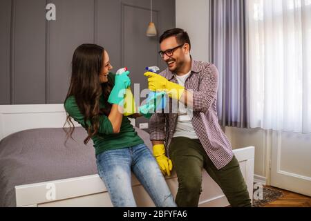 Junge glückliches Paar ist Spaß zu haben, während Ihre Reinigung der Wohnung. Stockfoto