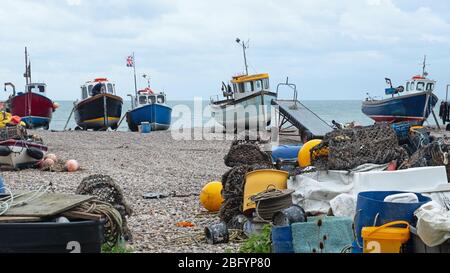 Beer, England – 13. November 2019: Ein nicht identifizierter Fischer, der an einem der Boote der lokalen Fischereiflotte arbeitet, strandete am Kiesstrand Stockfoto