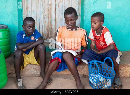 Omo Valley- Äthiopien - Afrika, Januar 01. 2013: Jungs mit Schulbuch vor seinem Haus im Omo Valley, Äthiopien, Afrika Stockfoto