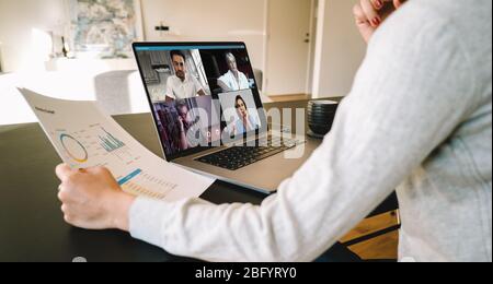 Gruppe von Geschäftsleuten und Geschäftsfrauen smart arbeiten von zu Hause aus. Blick von Seite der Frau, die mit ihren Kollegen über den Businessplan über einen Videocon spricht Stockfoto