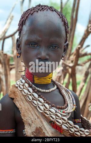 Omo Valley - Äthiopien - Afrika, 2. Januar 2013: Junges unidentifiziertes Mädchen des Hamer Stammes stehend mit traditionallen Ornamenten in Omo Val Stockfoto