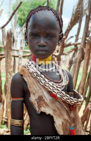 Omo Valley - Äthiopien - Afrika, 2. Januar 2013: Junges unidentifiziertes Mädchen des Hamer Stammes stehend mit traditionallen Ornamenten in Omo Val Stockfoto