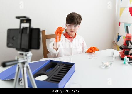 9-jähriger Junge macht pädagogisches Video über chemische Experimente Für seinen Vlog Stockfoto