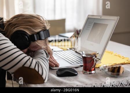 Erschöpftes Mädchen, das von zu Hause aus arbeitet Stockfoto