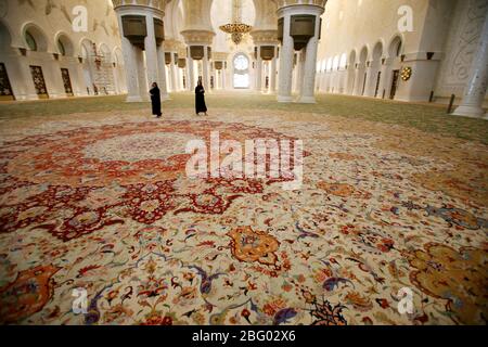 Bild ©lizenziert für Parsons Media. 20/07/2009. Abu Dhabi, Großbritannien. Tourist Walk auf dem größten Teppich der Welt in der Großen Zayed Moschee in Abu Dhabi die Hauptstadt der Vereinigten Arabischen Emirate ist die größte Moschee in den Vereinigten Arabischen Emiraten und die sechstgrößte Moschee der Welt. Benannt ist es nach Scheich Zayed bin Sultan Al Nahyan, dem Gründer und ersten Präsidenten der Vereinigten Arabischen Emirate, der ebenfalls dort begraben ist. Die Moschee wurde offiziell im islamischen Monat Ramadan im Jahr 2007 eröffnet, Es ändert sich die Farbe je nach Mondkreis.Bild von Andrew Parsons / Parsons Me Stockfoto