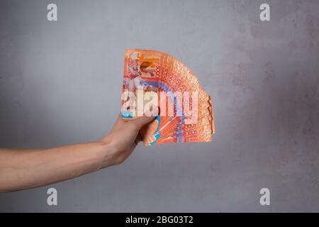 Hand halten eine Menge Geld. Tenge KZT. Nationale Währung von Kasachstan, KZ. Wechselkurs. Wirtschaft, Entwicklung, Handel und Unternehmen, Bank, Broker. Banknote Stockfoto