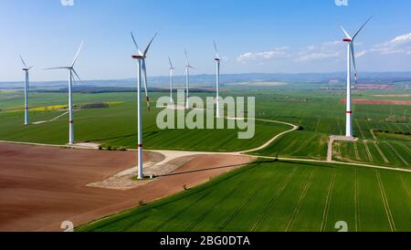 Wipperdorf, Deutschland. April 2020. Windturbinen in einem Windpark stehen noch für Windmangel. Insgesamt sieben Windenergieanlagen, darunter die höchste Windkraftanlage Thüringens (r) mit einer Höhe von fast 240m, erzeugen hier 18.9 Megawatt Nennleistung. (Luftaufnahme mit Drohne) Quelle: Jan Woitas/dpa-Zentralbild/dpa/Alamy Live News Stockfoto