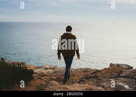Porträt des jungen Mannes, der im Freien am Meer spazieren geht Stockfoto