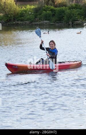 Kajakfahrerin paddeln auf dem Trenance Bootsee in Newquay in Cornwall. Stockfoto