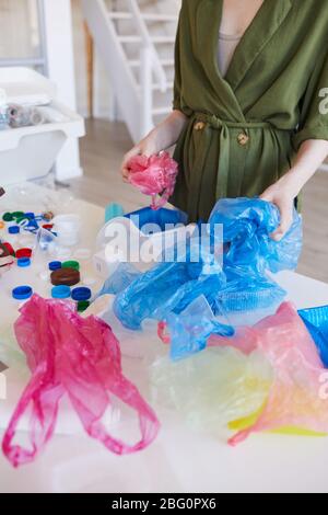 Mittelteil Porträt der modernen Frau Sortierung von Kunststoffabfällen zu Hause vor dem Recycling, Kopierraum Stockfoto