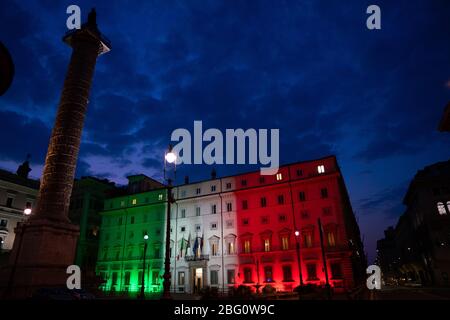 Rom, Italien - 8. April 2020: Palazzo Chigi, Sitz der italienischen Regierung, Fassade des Gebäudes mit den Farben der italienischen Flagge d beleuchtet Stockfoto