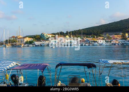 Malerischer Blick auf den Hafen von Fiskardo mit den Segelbooten und den bunten traditionellen Häusern bei Sonnenuntergang in Kefalonia, Griechenland Stockfoto